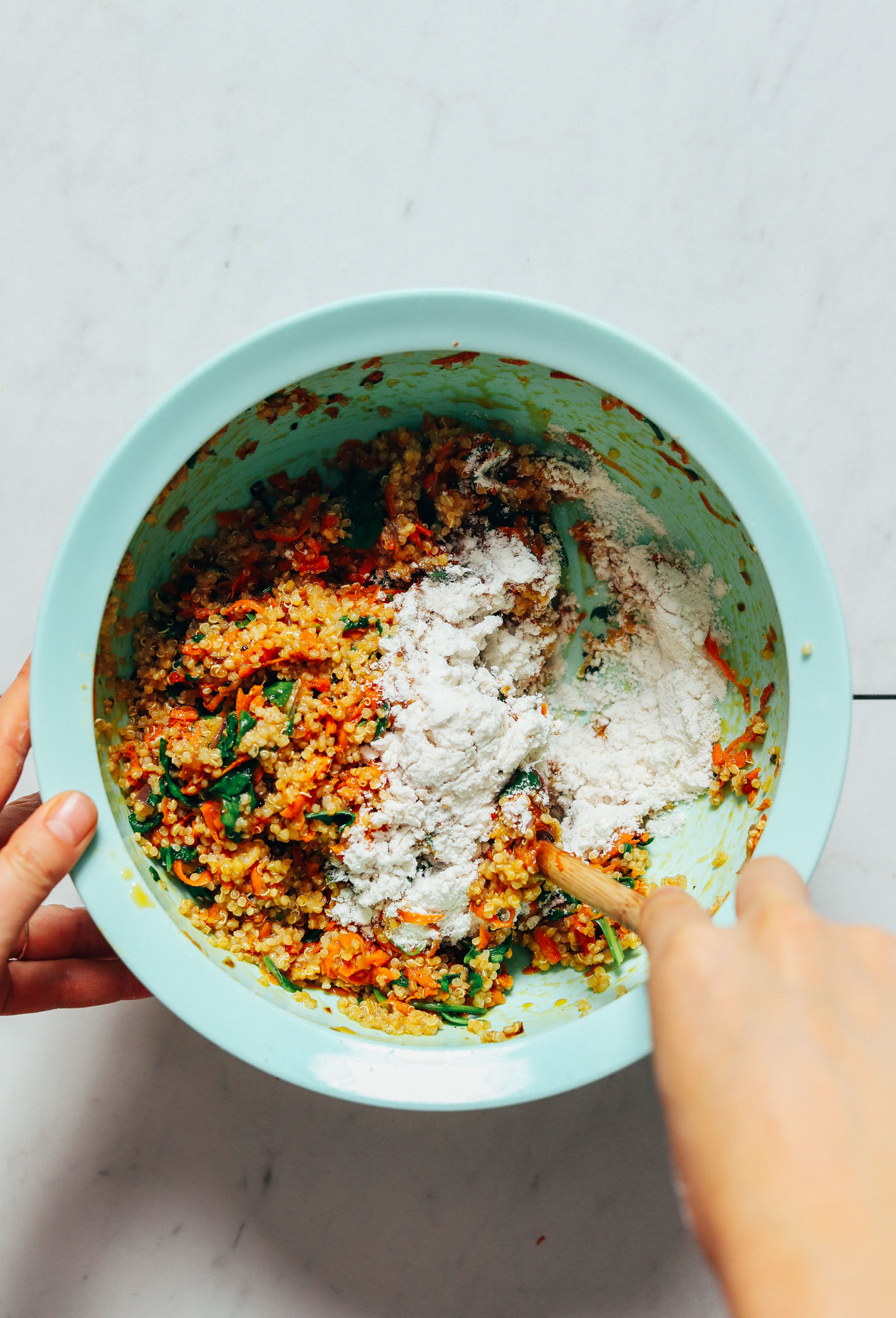 Stirring gluten-free flour into the batter for making Quinoa Sweet Potato Fritters