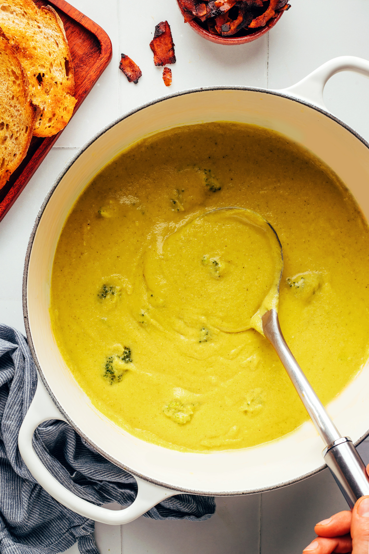 Chunks of broccoli in a pot of creamy vegan broccoli cheddar soup