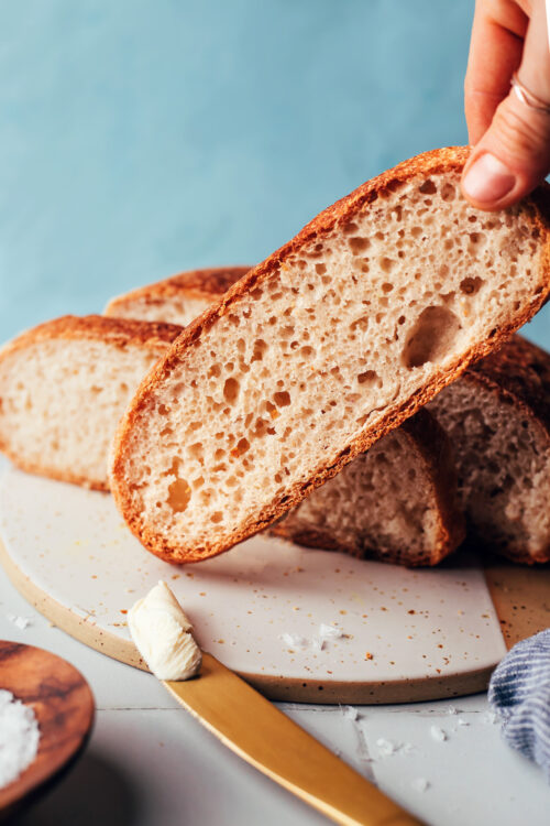 Holding up a slice of a gluten-free artisan-style bread