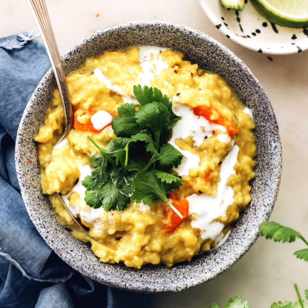 Bowl of kitchari topped with coconut milk and cilantro