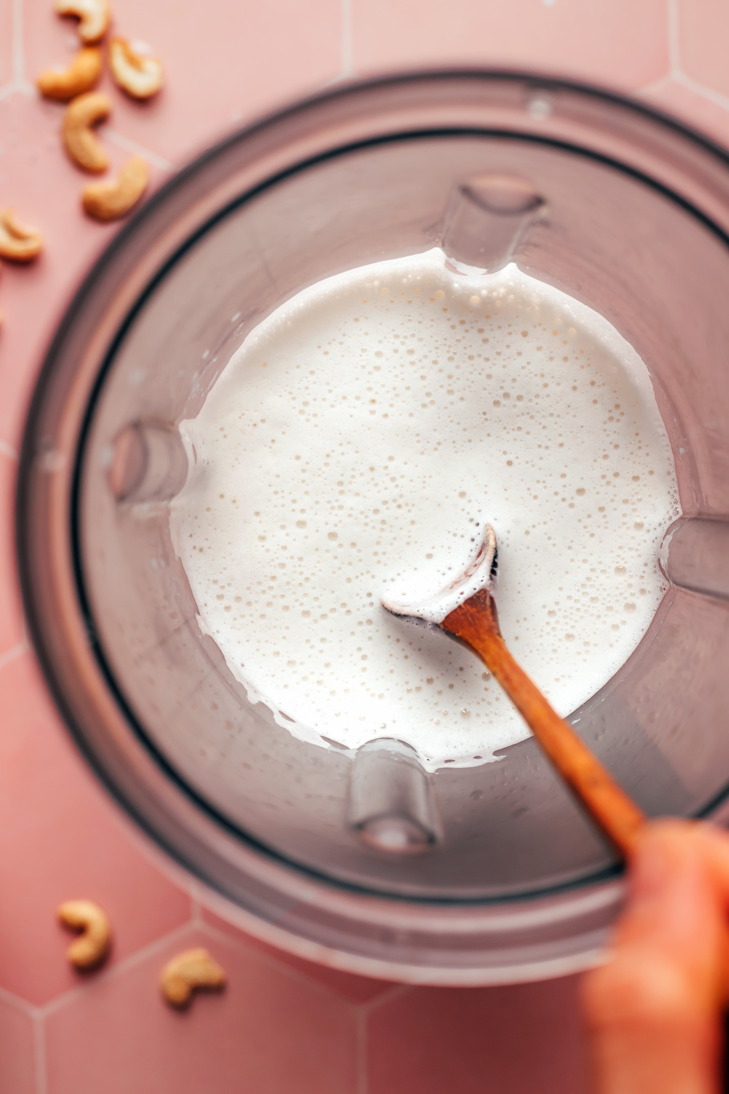 Stirring homemade cashew milk in a blender