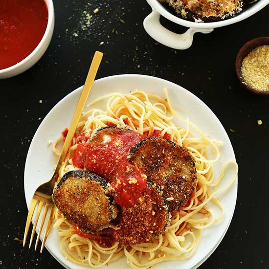 Plate of pasta topped with marinara and Vegan Eggplant Parmesan