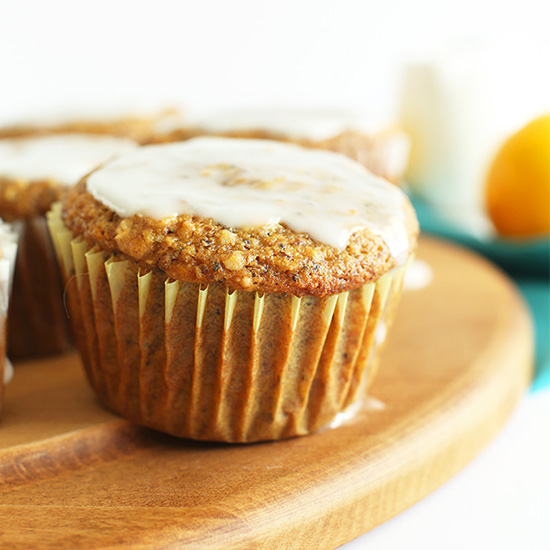 Cutting board with Meyer Lemon Poppy Seed Muffins topped with icing