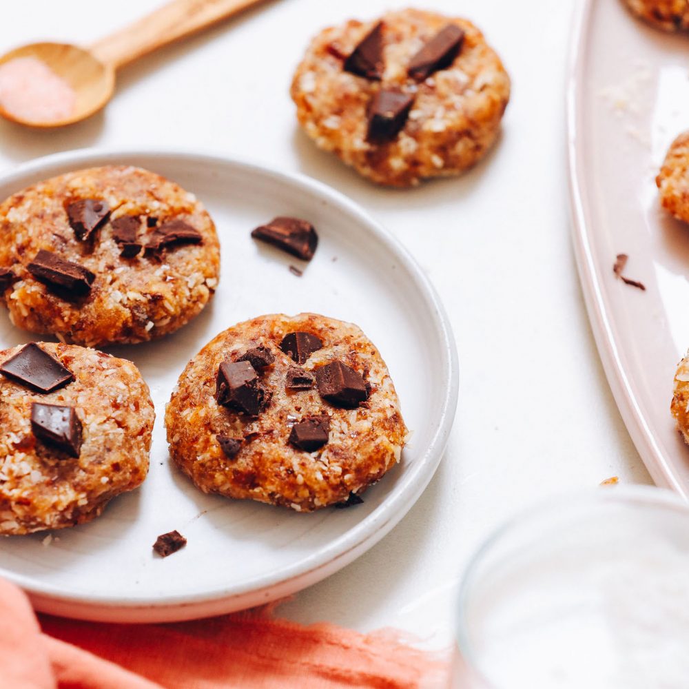 Spoonful of sea salt next to four of our no bake chocolate chip cookies