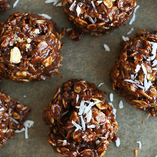 Parchment-lined baking sheet of No Bake Cookies topped with shredded coconut