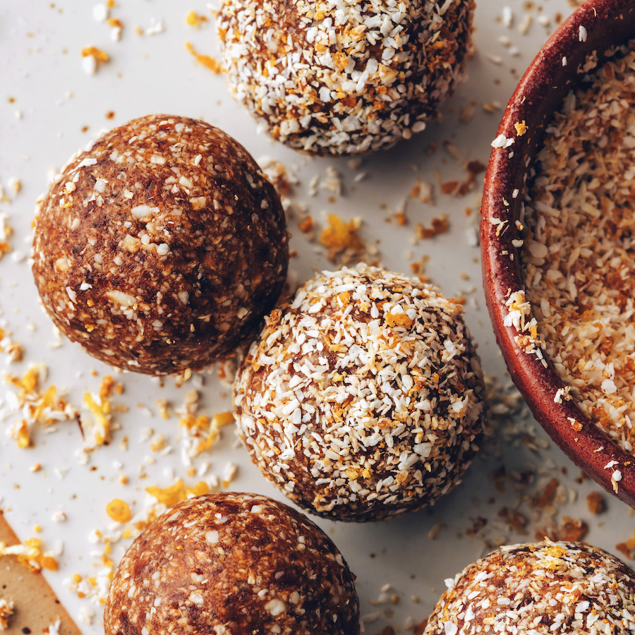 Orange cardamom energy bites with some coated in a coconut orange zest topping