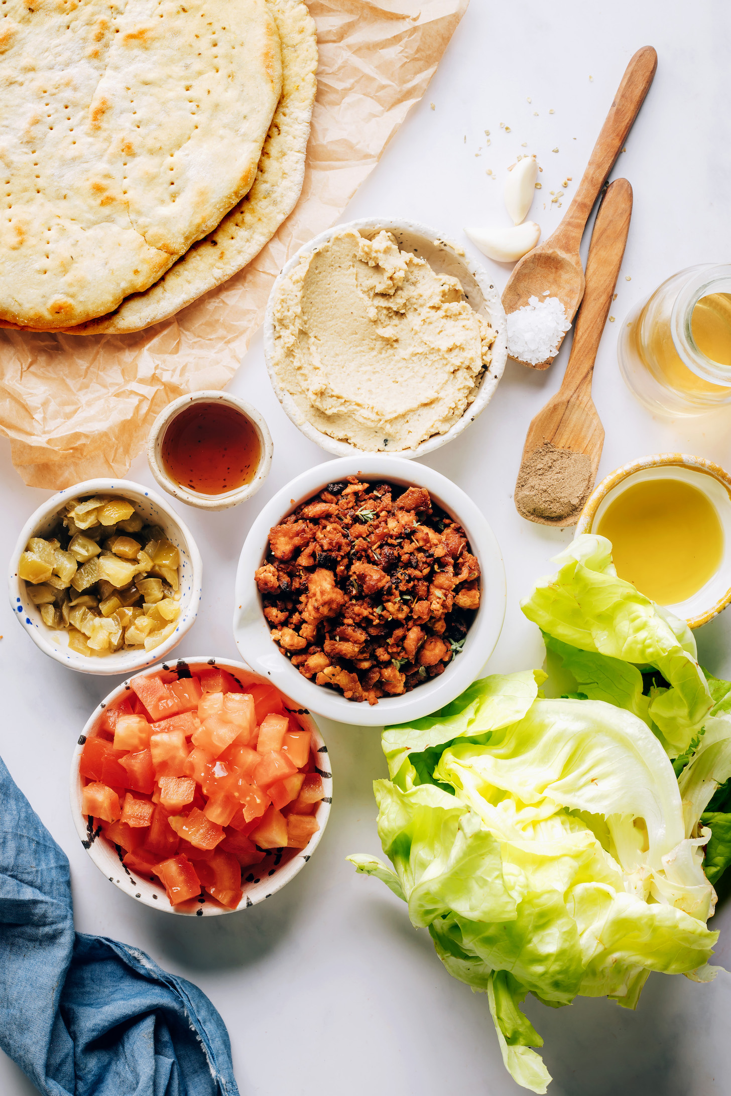 Pita bread, hummus, maple syrup, pepperoncini, tomato, lettuce, baked tofu, olive oil, salt, pepper, and garlic