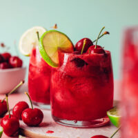 Glasses of sparkling cherry limeade with fresh cherries and limes