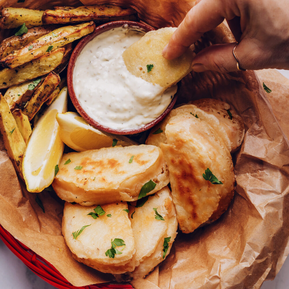 Dipping vegan fish into tartar sauce