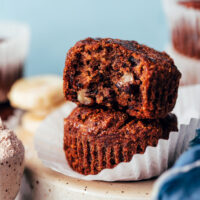 Stack of two banana buckwheat muffins with the first one partially eaten to show the texture