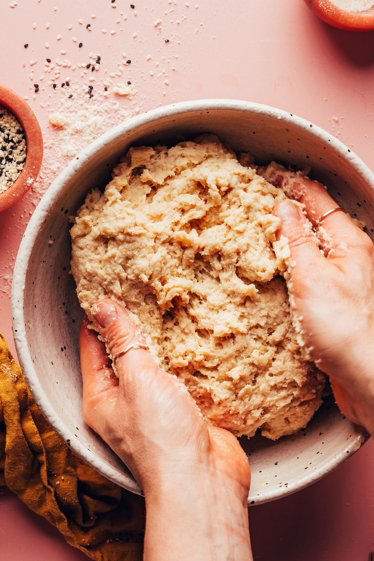 Mixing vegan gluten-free hamburger bun dough by hand to ensure no flour pockets remain