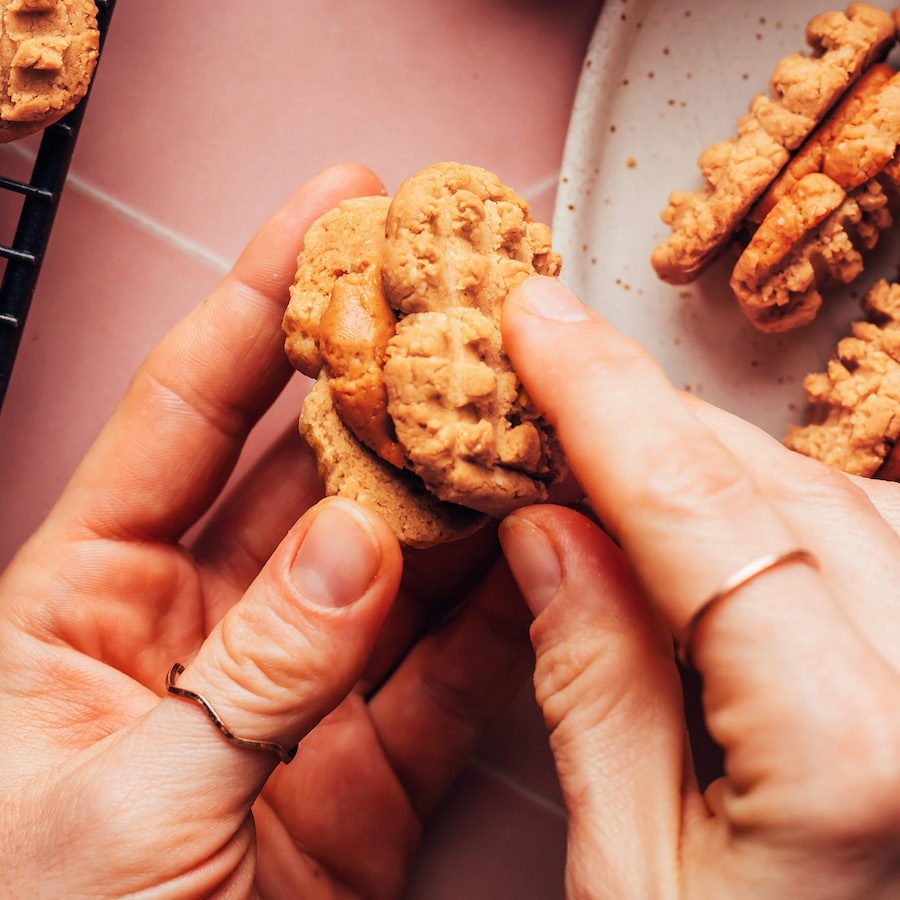 Creating a nutter butter by sandwiching peanut butter filling between crispy peanut butter cookies