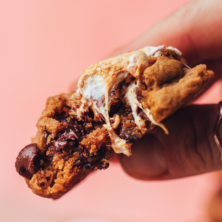 Holding up a partially eaten s'mores cookie to show the melty chocolate and gooey marshmallows