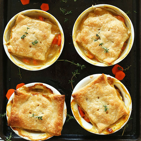 Four ramekins of White Bean & Thyme Mini Vegan Pot Pies on a baking sheet